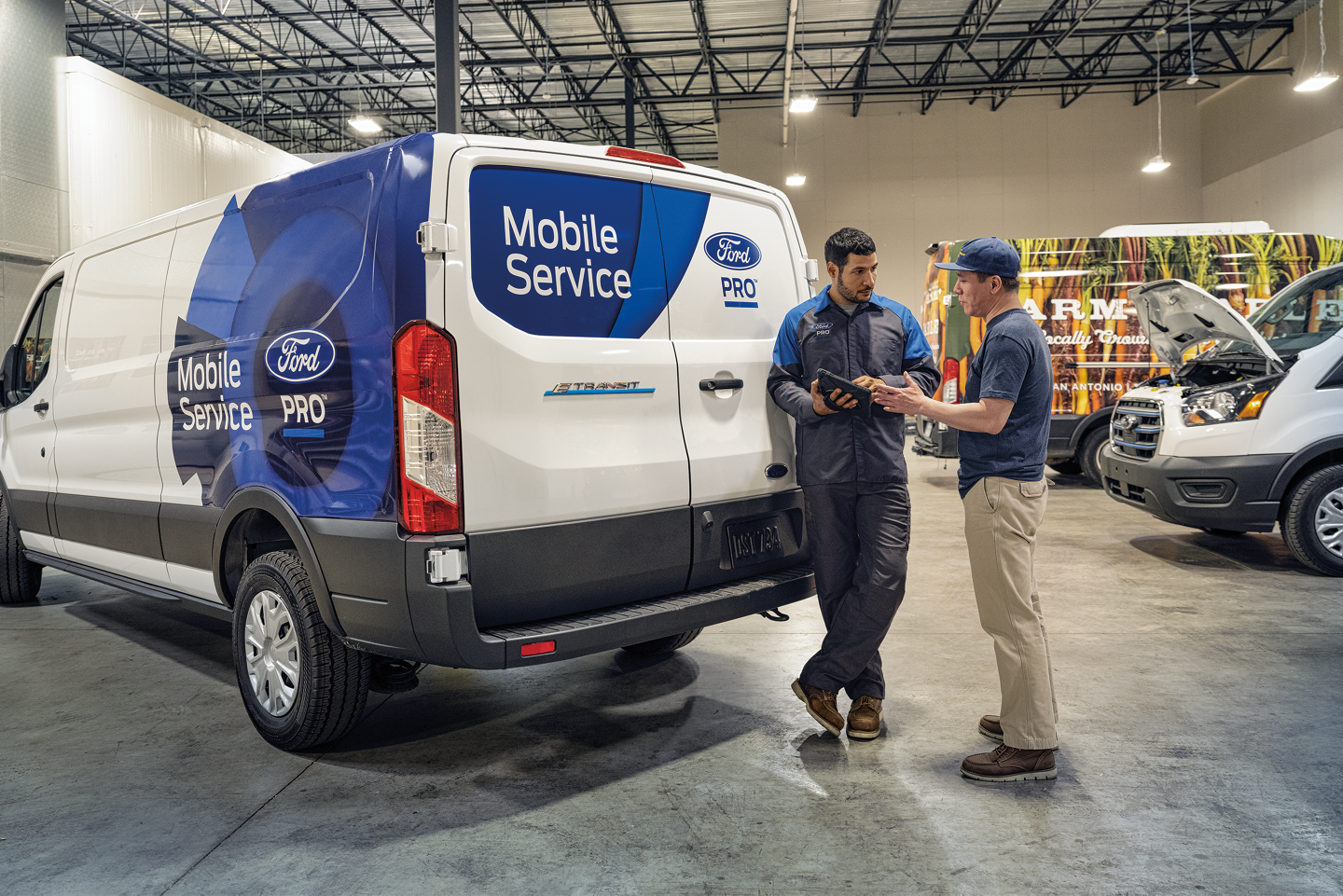 A Ford Mobile Service tech talks to a fleet owner about their service needs