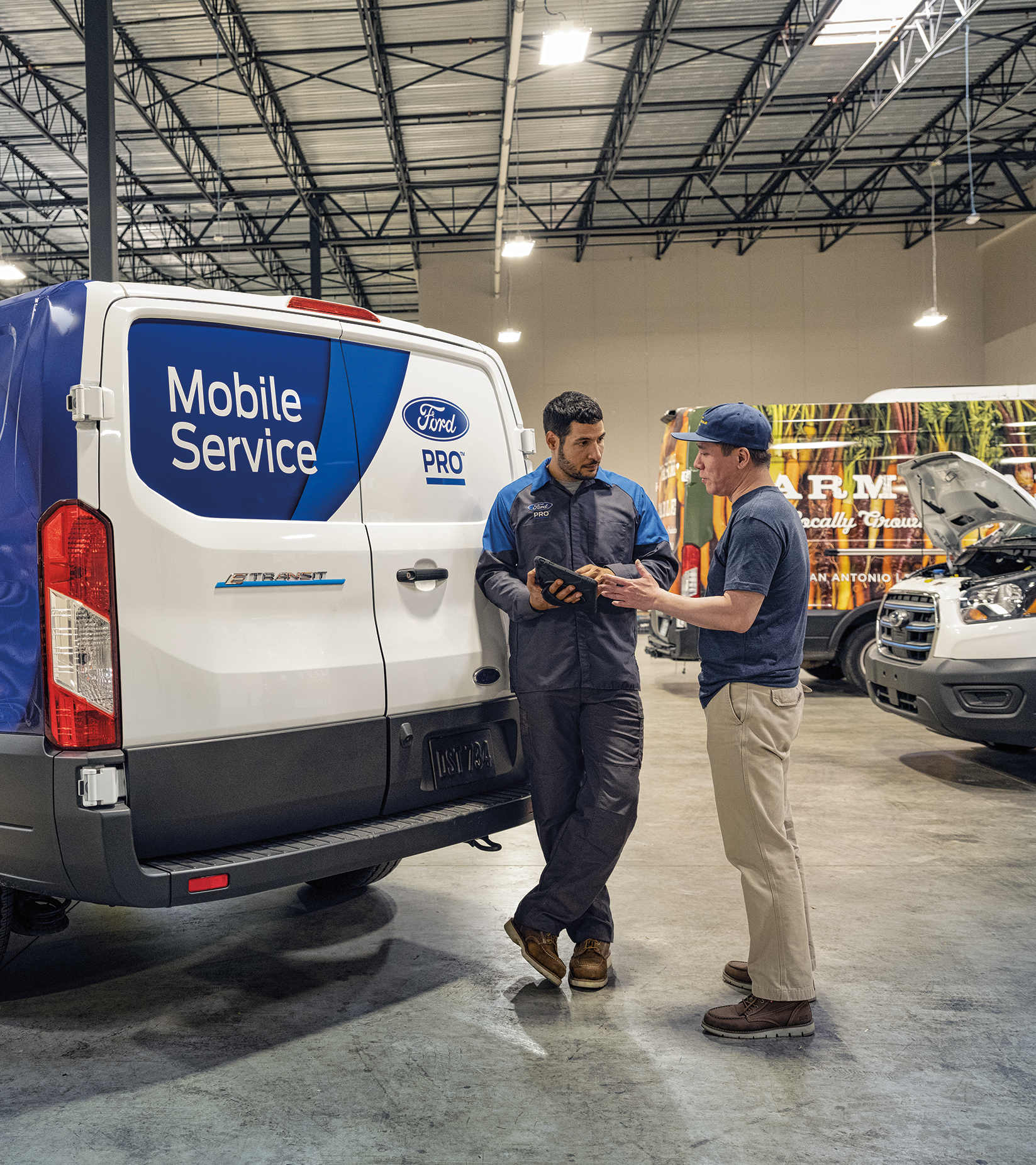 A Ford Mobile Service tech talks to a fleet owner about their service needs