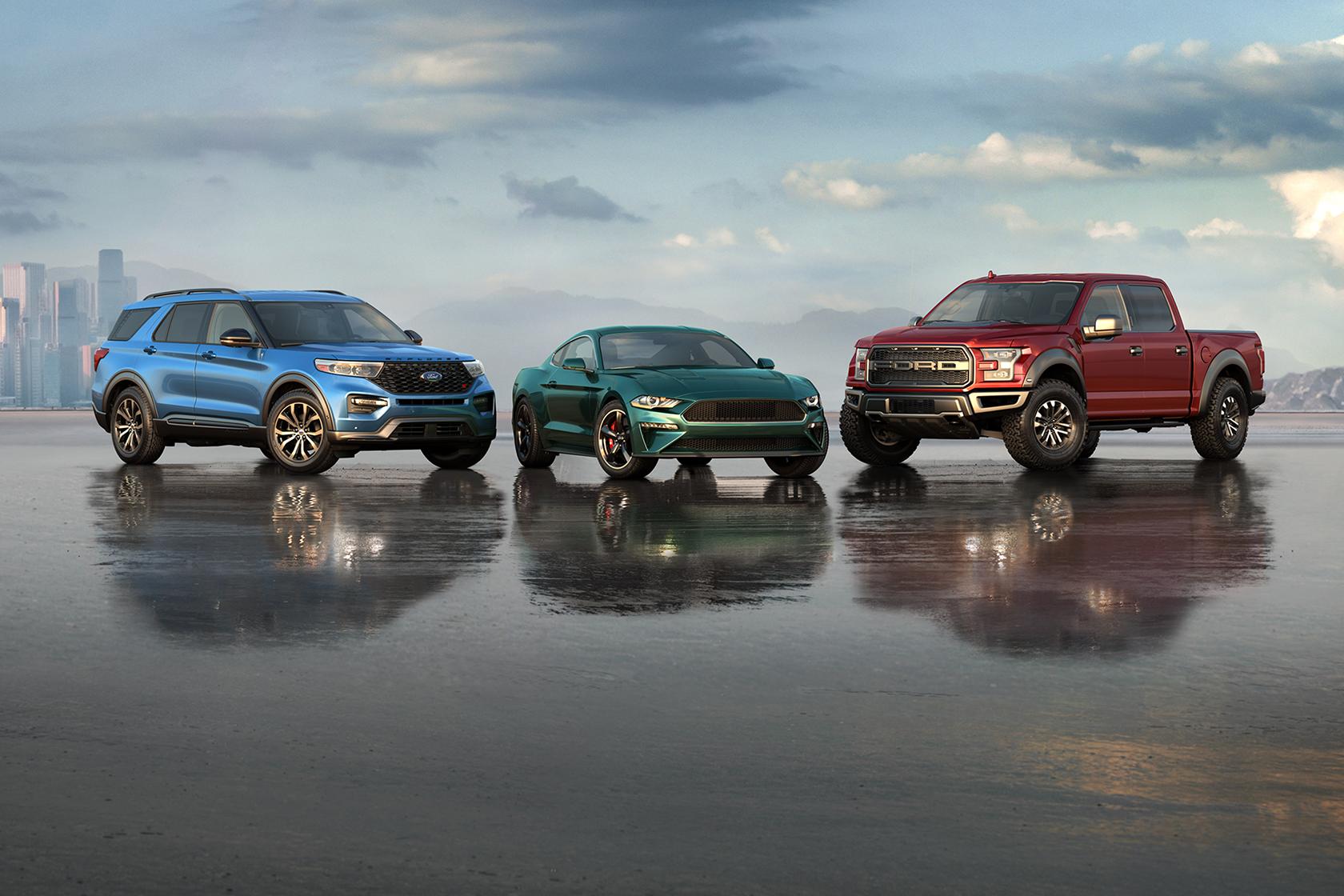 The Ford Explorer® SUV, Mustang® coupe, and F-150® pickup lineup are parked in front of a city skyline off in the distance
