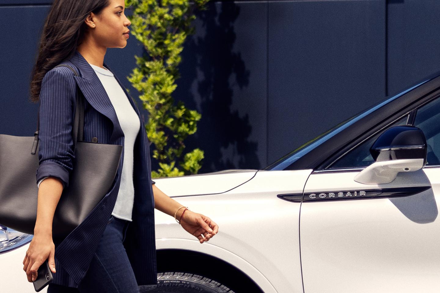 A person approaches a 2025 Lincoln Corsair® Reserve model while holding a mobile phone