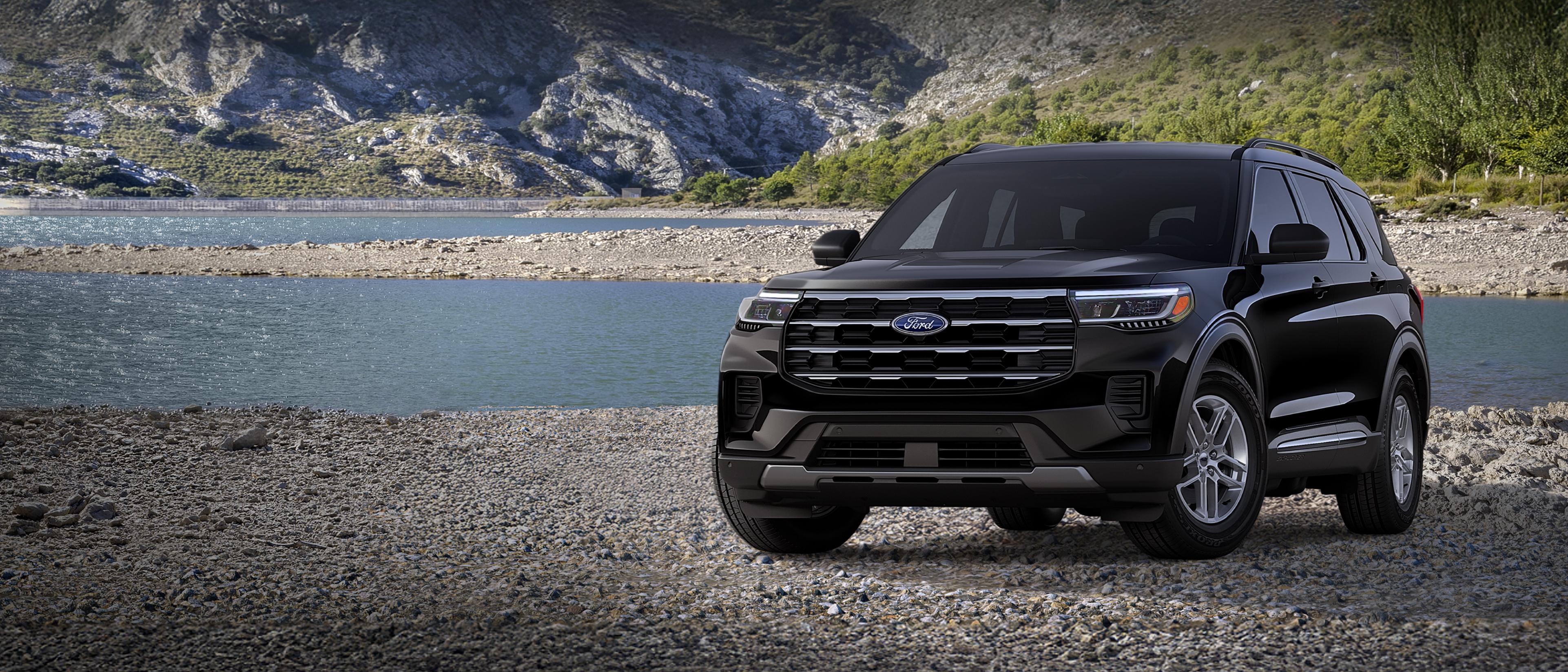 A 2026 Ford Explorer® Active model parked on a rocky expanse near a mountain lake