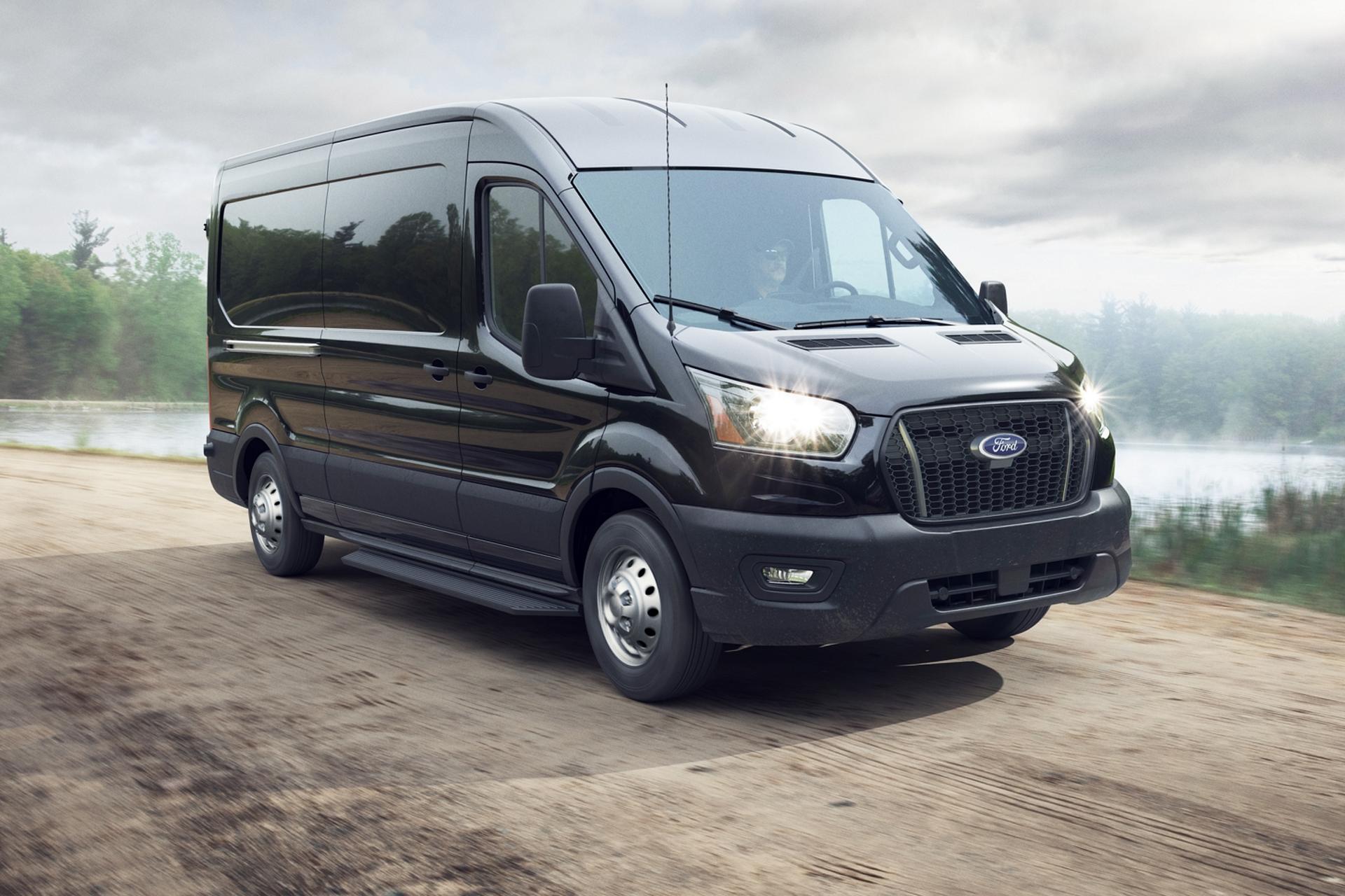 Black 2026 Ford Transit® van being driven near a lake