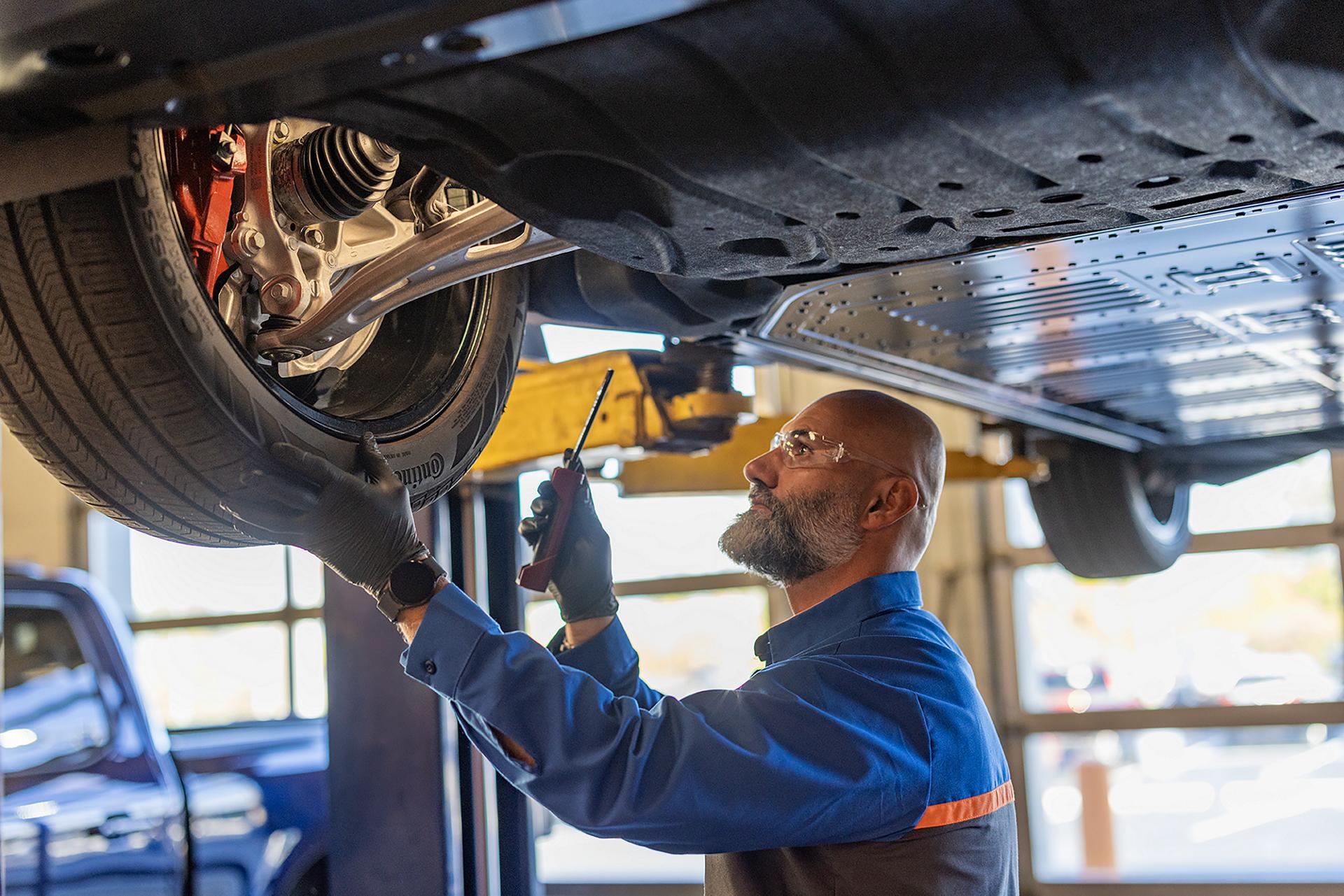 A Ford Service garage with a man performing maintenance on a 2025 Ford Mustang Mach-E®