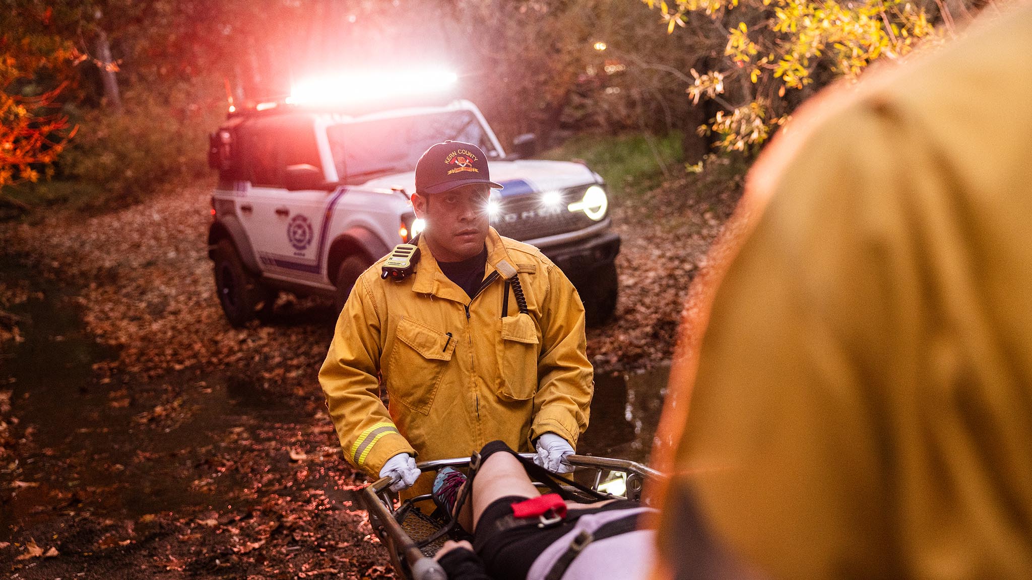 First responders carrying an injured person on a stretcher toward their Ford Bronco Badlands. 