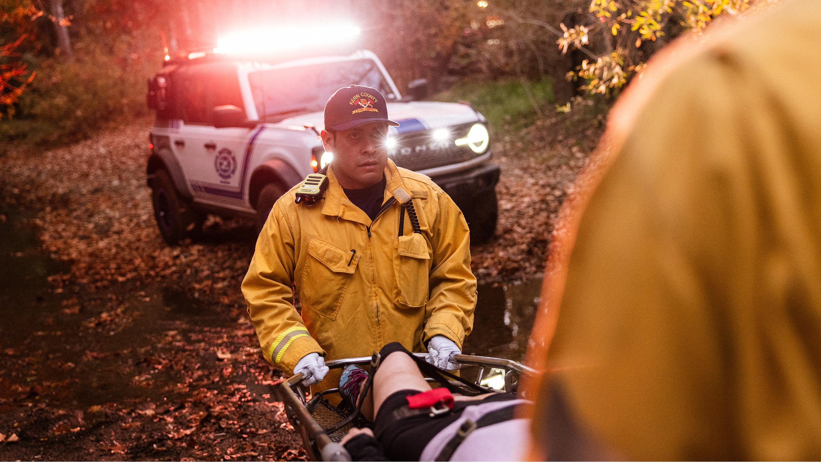 First responders carrying an injured person on a stretcher toward their Ford Bronco Badlands. 