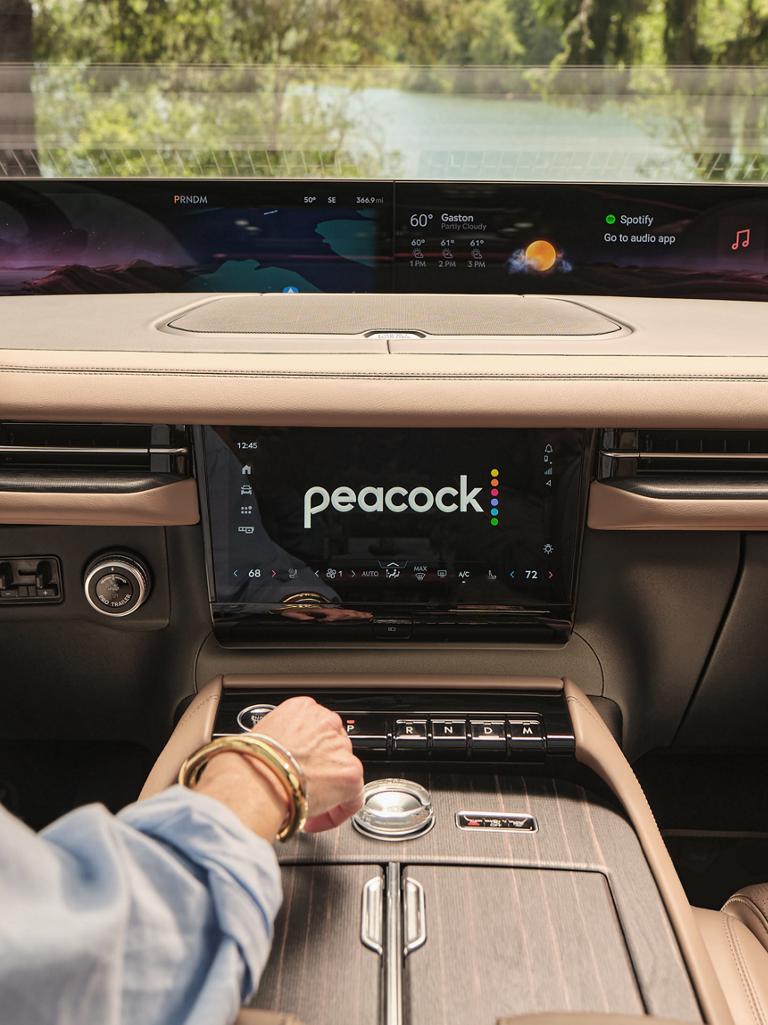 The interior of a 2026 Lincoln Black Label Navigator with a streaming app displayed on the center stack screen