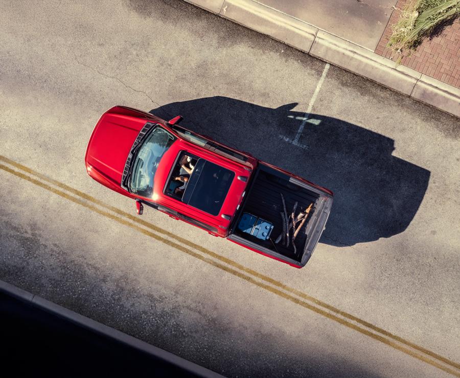 An aerial view of two people in a 2025 Ford F-150® Lightning® featuring the sunroof and cargo in the truck bed