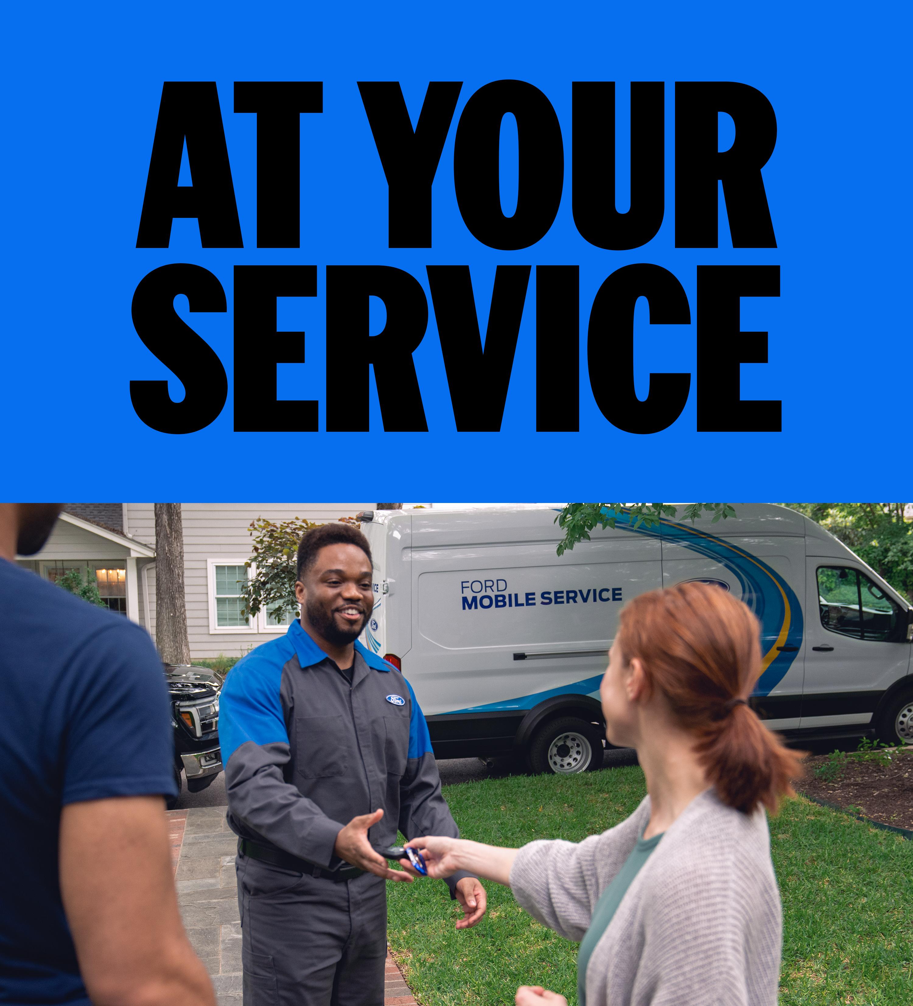 A woman handing her keys to the Ford Service technician that is standing in her driveway