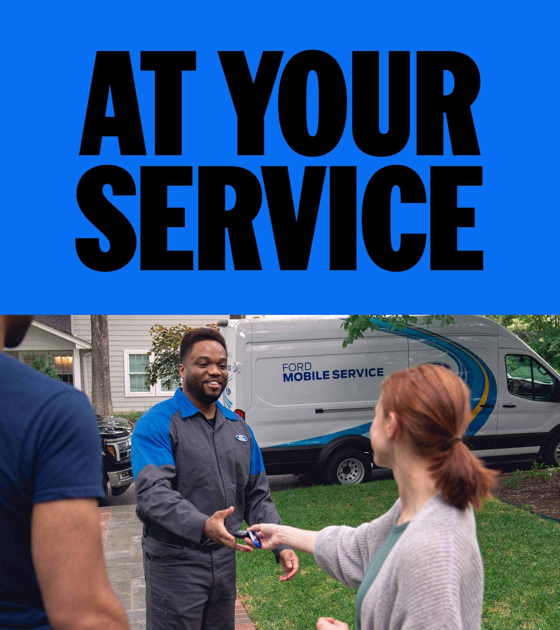 A woman handing her keys to the Ford Service technician that is standing in her driveway