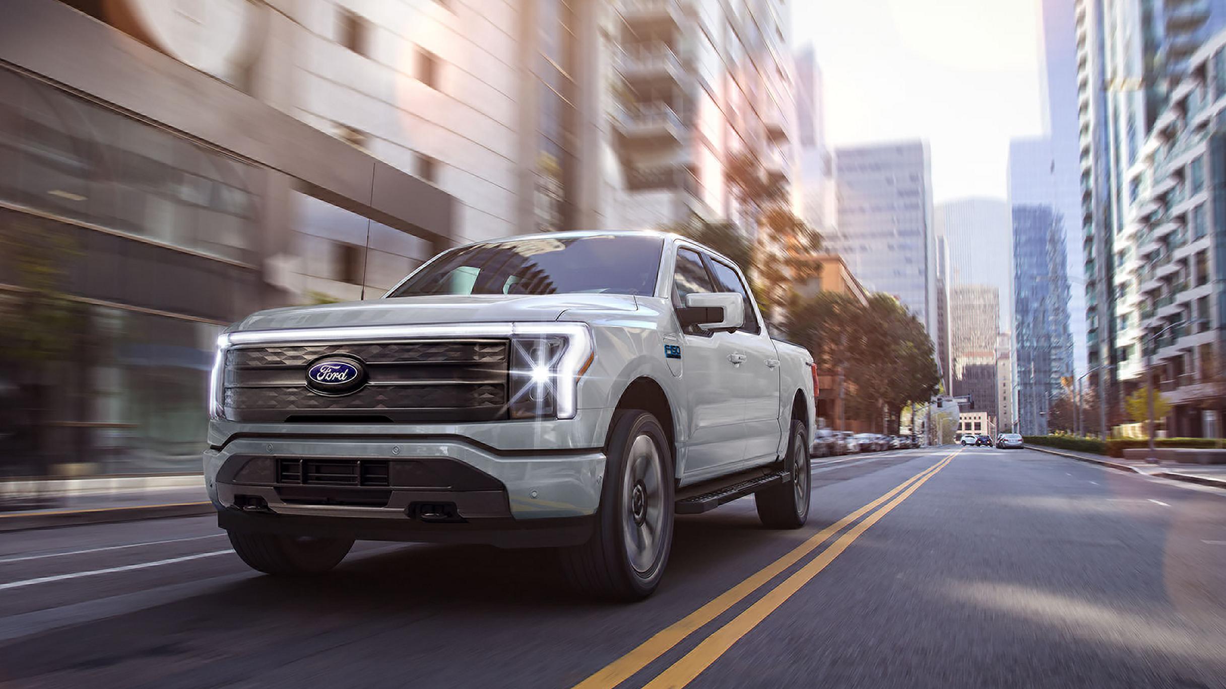 A 2025 Ford F-150® Lightning® pickup driving down a city street