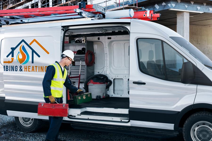 A worker loading a toolbox into the side of an open 2025 Ford Transit® van