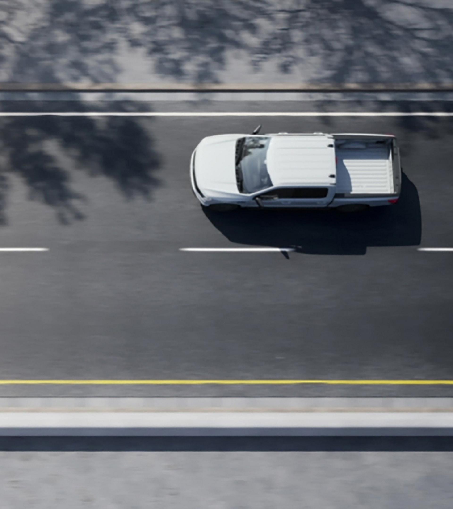 Over-head shot of a 2025 Ford F-150 Lightning driving down two-lane road
