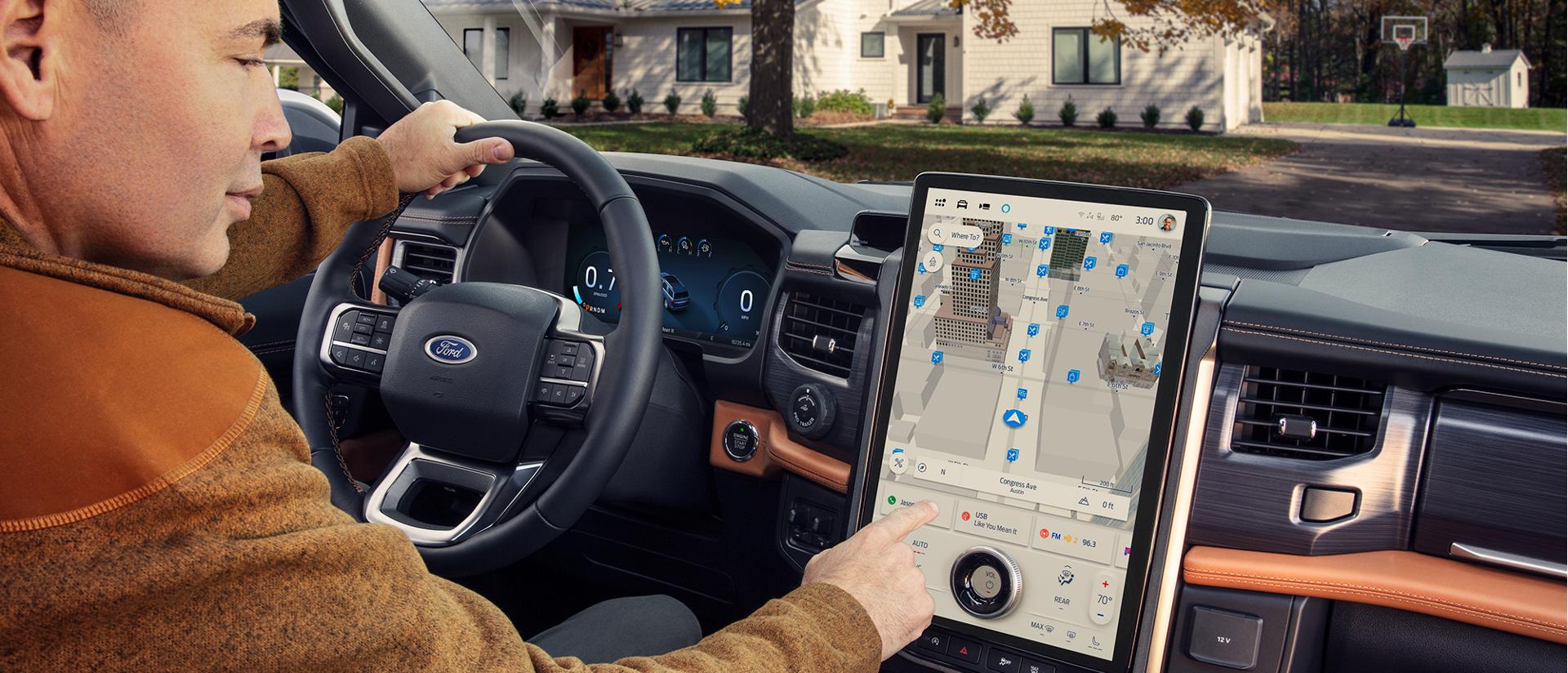Una persona usando Navegación Conectada en la pantalla central de una Ford vehículo estacionado