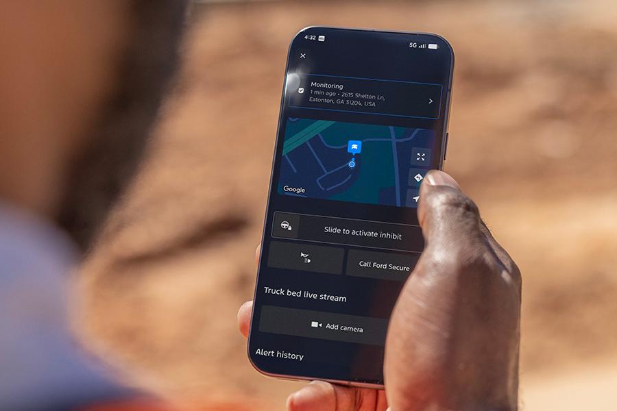 Person holding a phone displaying the Start Inhibit feature