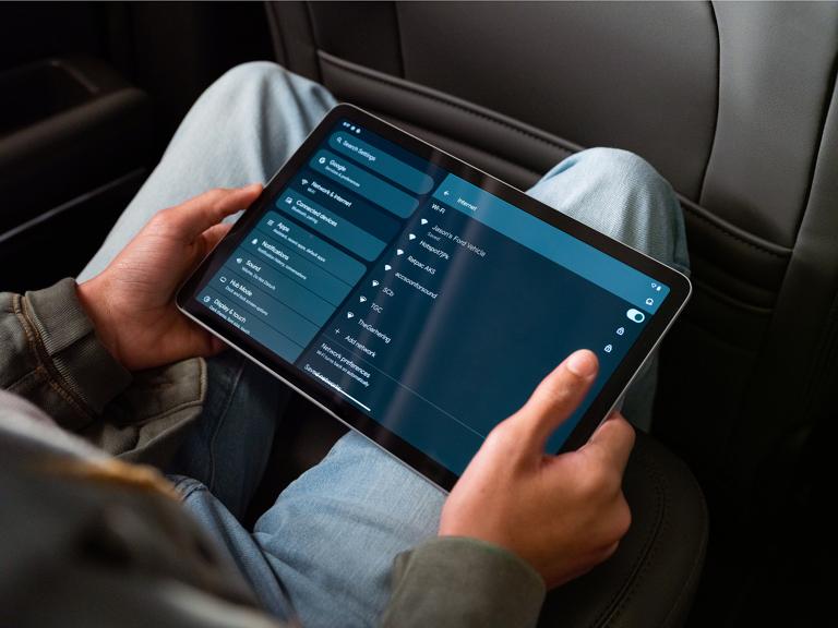 A passenger using a tablet in the rear seat of a 2026 Ford Bronco® SUV