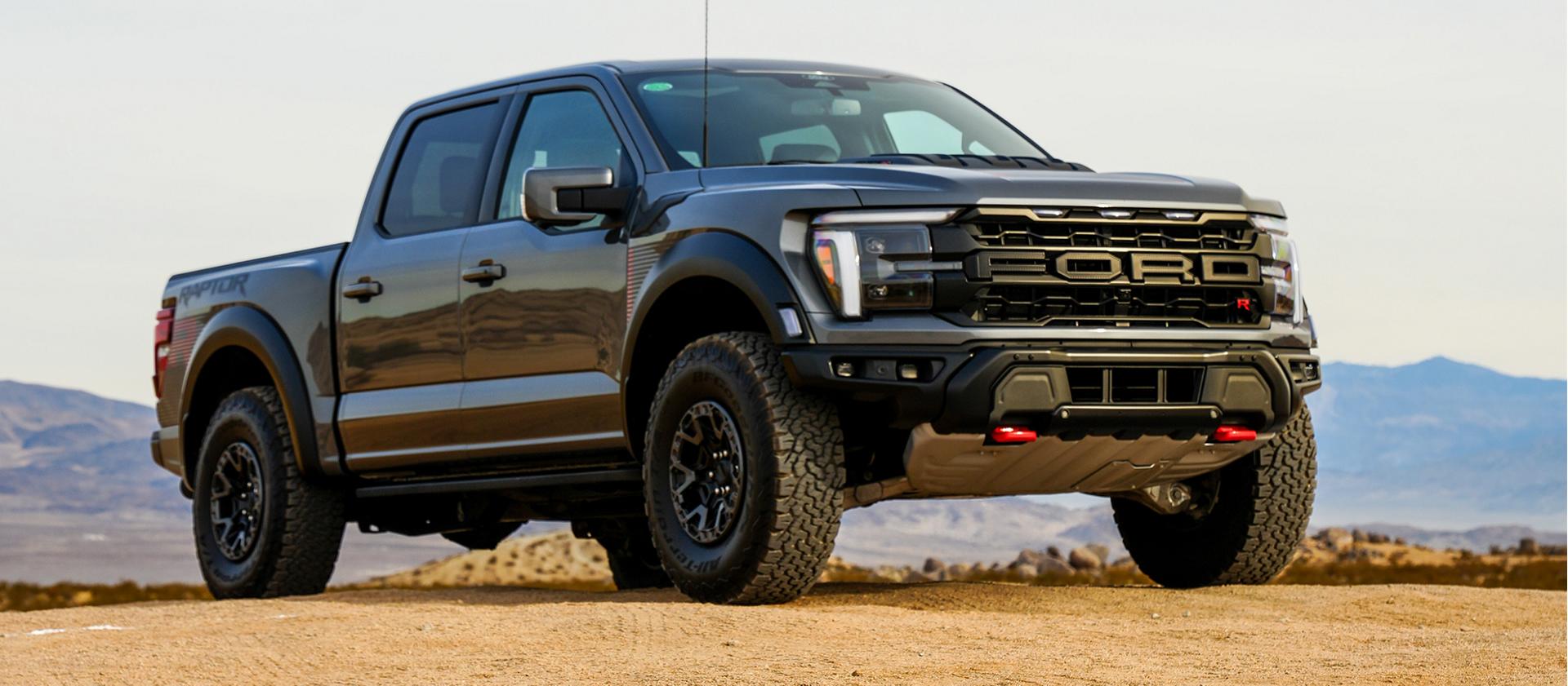 A 2024 Ford F-150® Raptor® R™ parked on a desert landscape, hills rising in the background