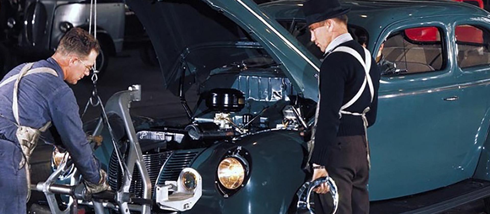 Two line workers and two teal vehicles