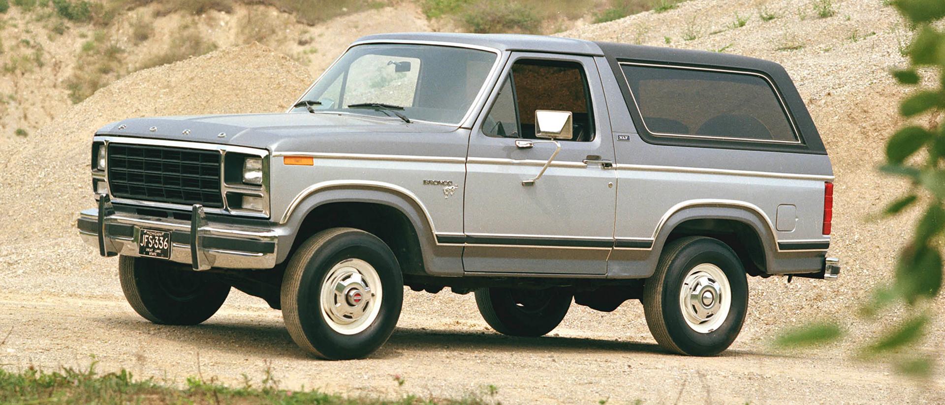 A two-tone grey 1981 Ford Bronco® XLT model parked on a rocky trial