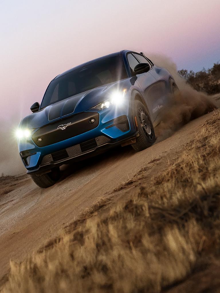 2026 Ford Mustang Mach-E® Rally model on a dirt road with a cloud of dust