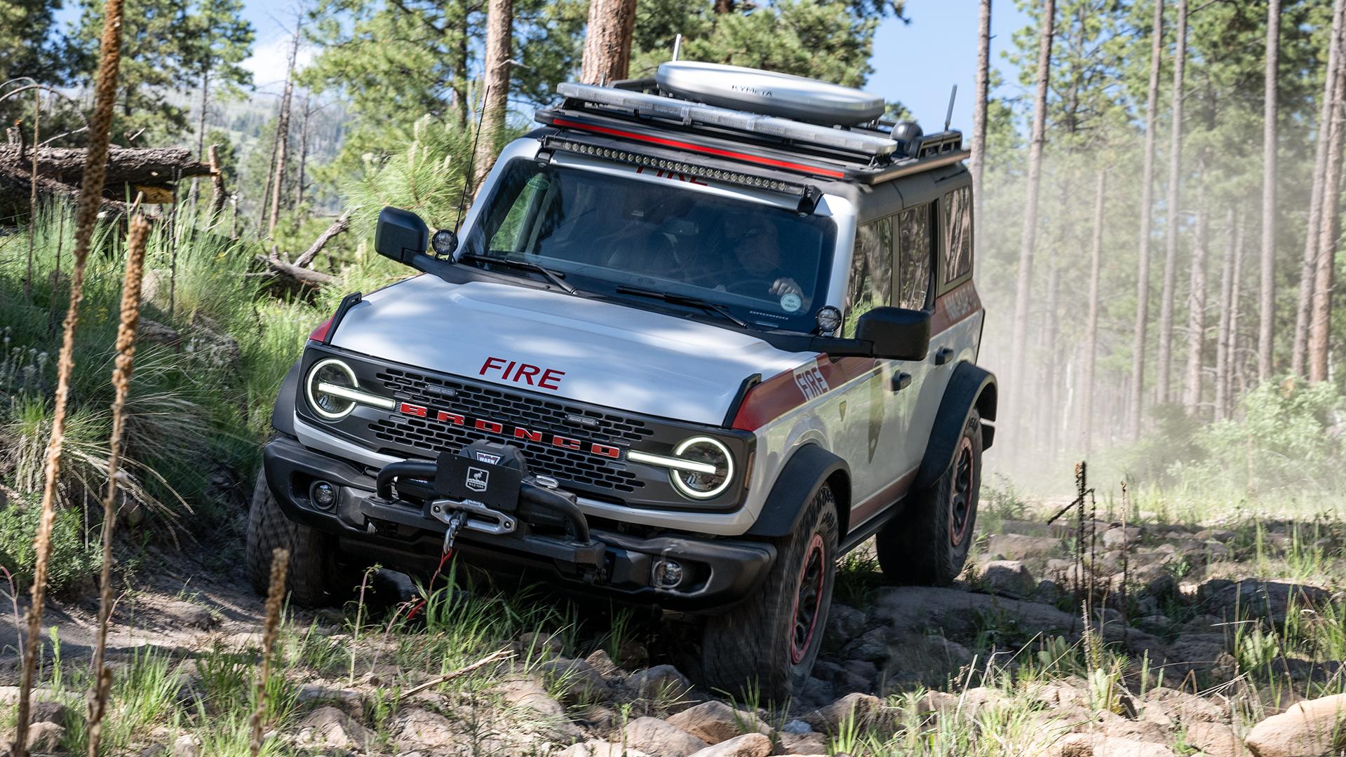 A National Park Service Ford Bronco Badlands with special equipment traversing a trail filled with small boulders.