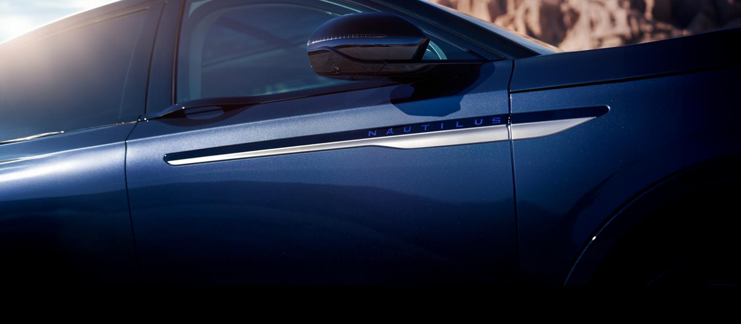 Two Lincoln vehicles are shown parked side by side in front of the ocean.