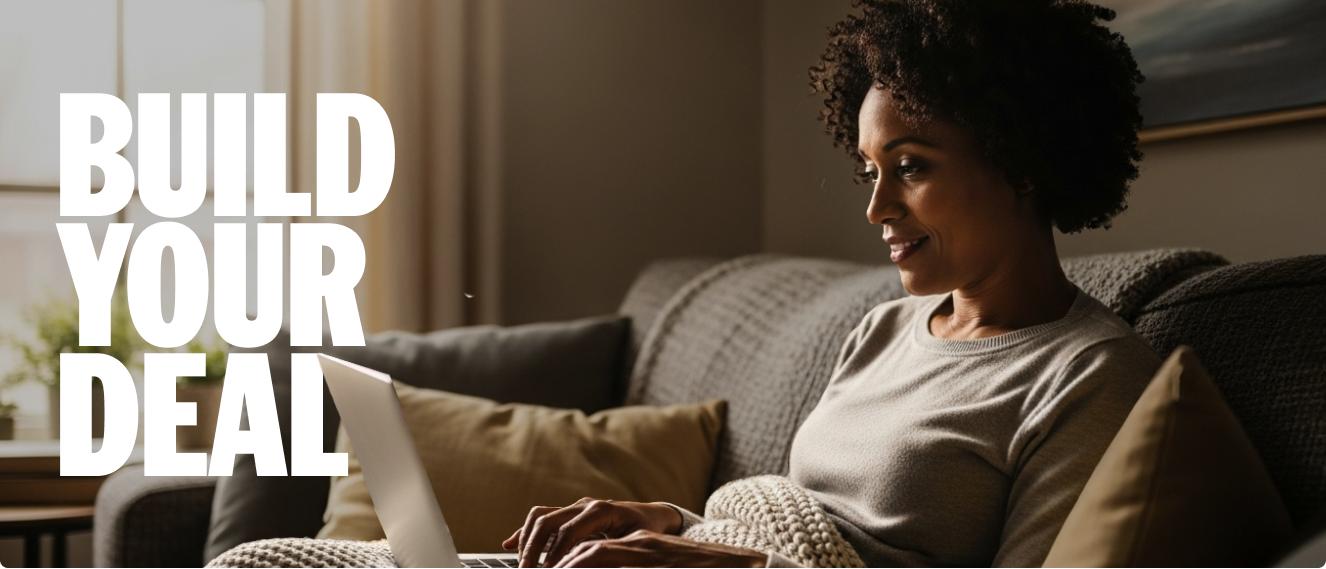 A woman shops on a laptop while sitting on a couch in her living room