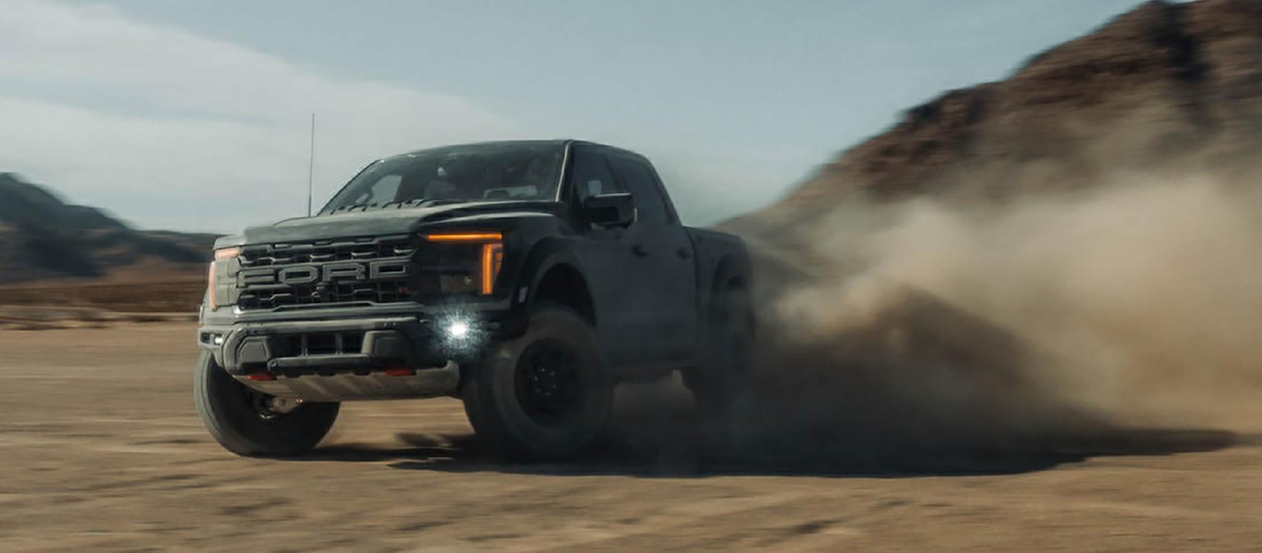 2026 Ford F-150® Raptor R™ truck being driven in the desert kicking up cloud of sand