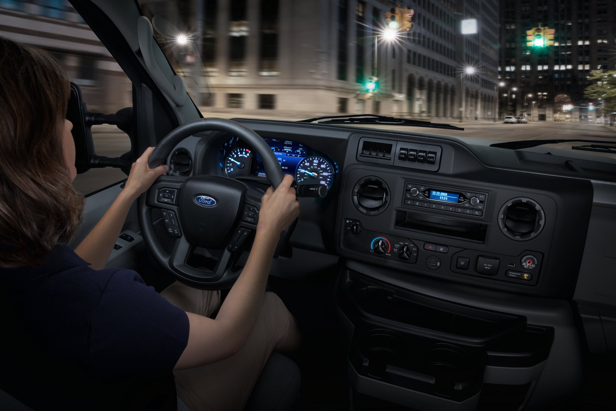 A woman in the driver’s seat of a 2025 Ford E-Series Cutaway