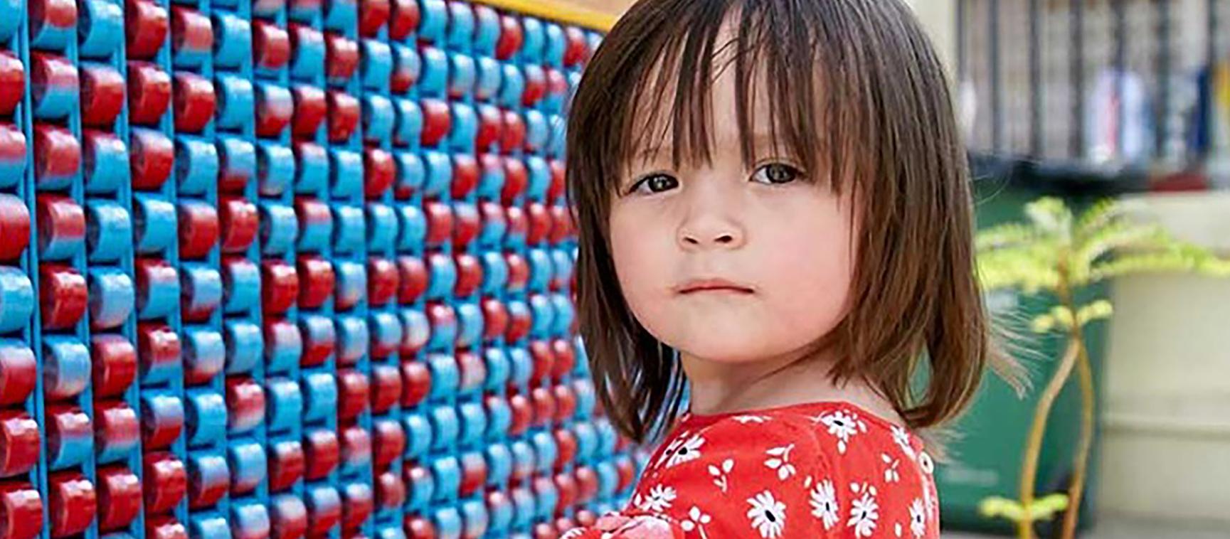 Little girl with blue and red wall