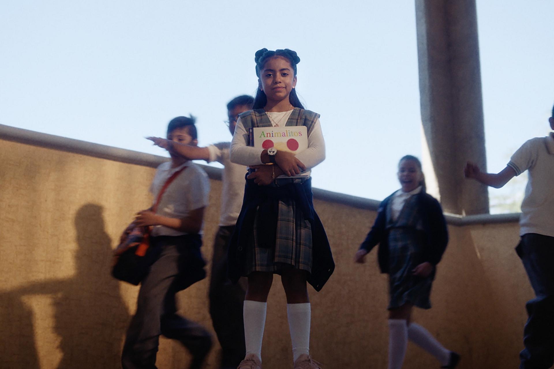 Little kid holding a book at schools stairs