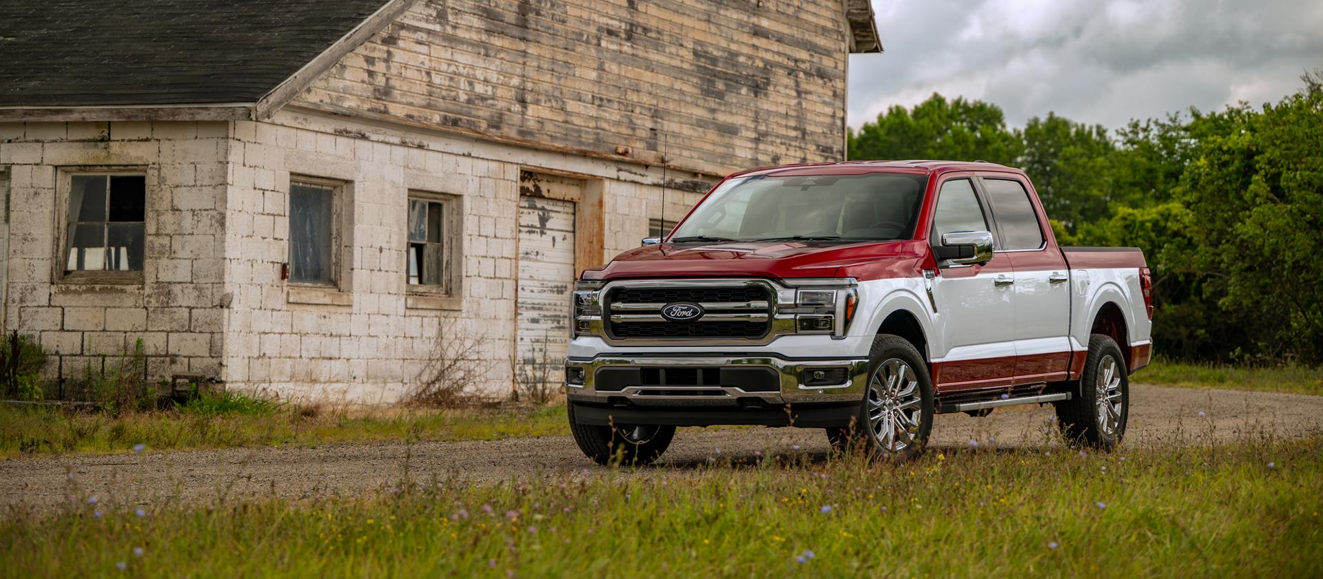 2027 Ford F-150® with Two-Tone Package parked in front of a rustic building, featuring a red roof and hood, white body