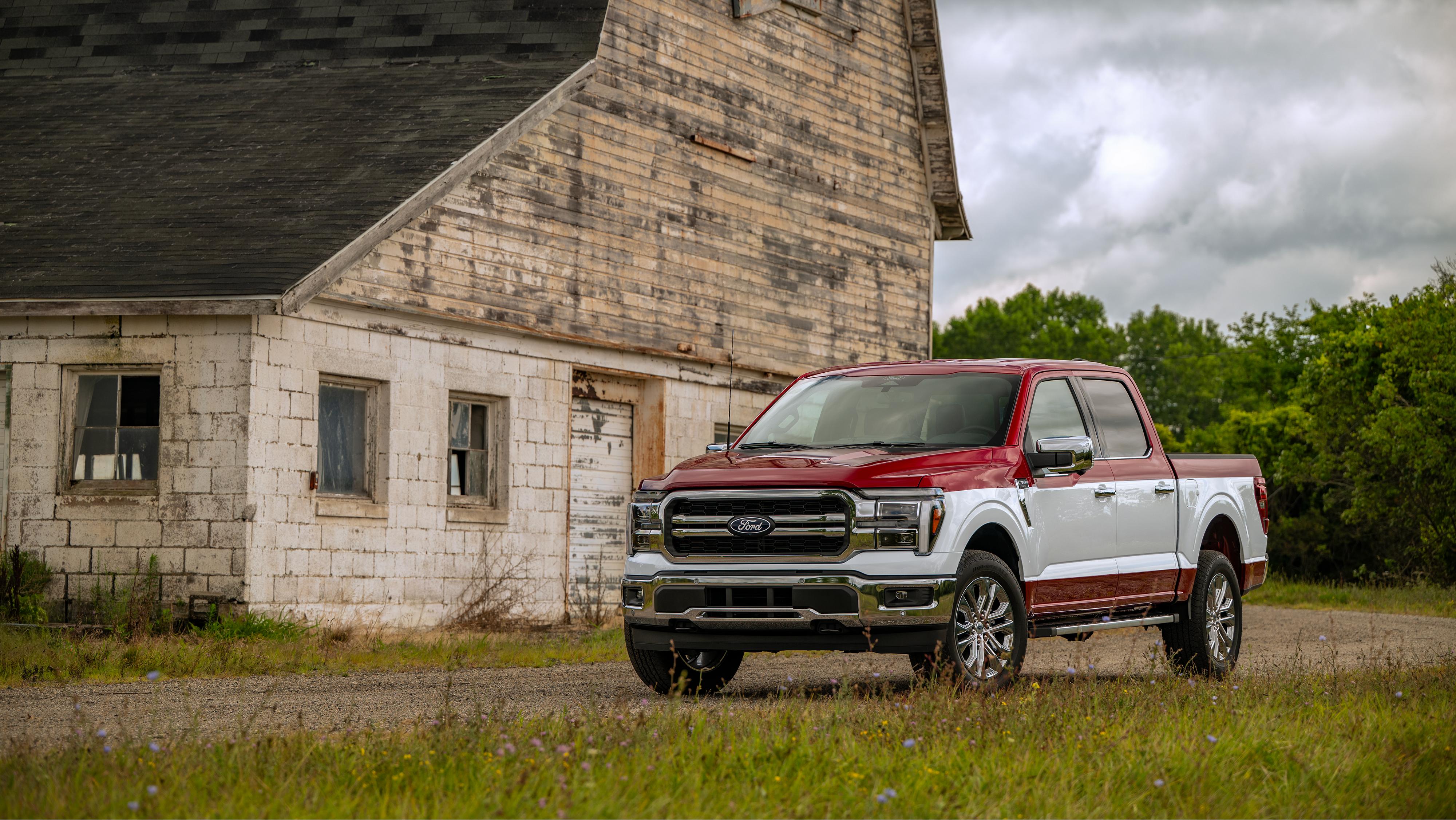 2027 Ford F-150 with Two-Tone Package parked in front of a rustic building, featuring a red roof and hood, white body