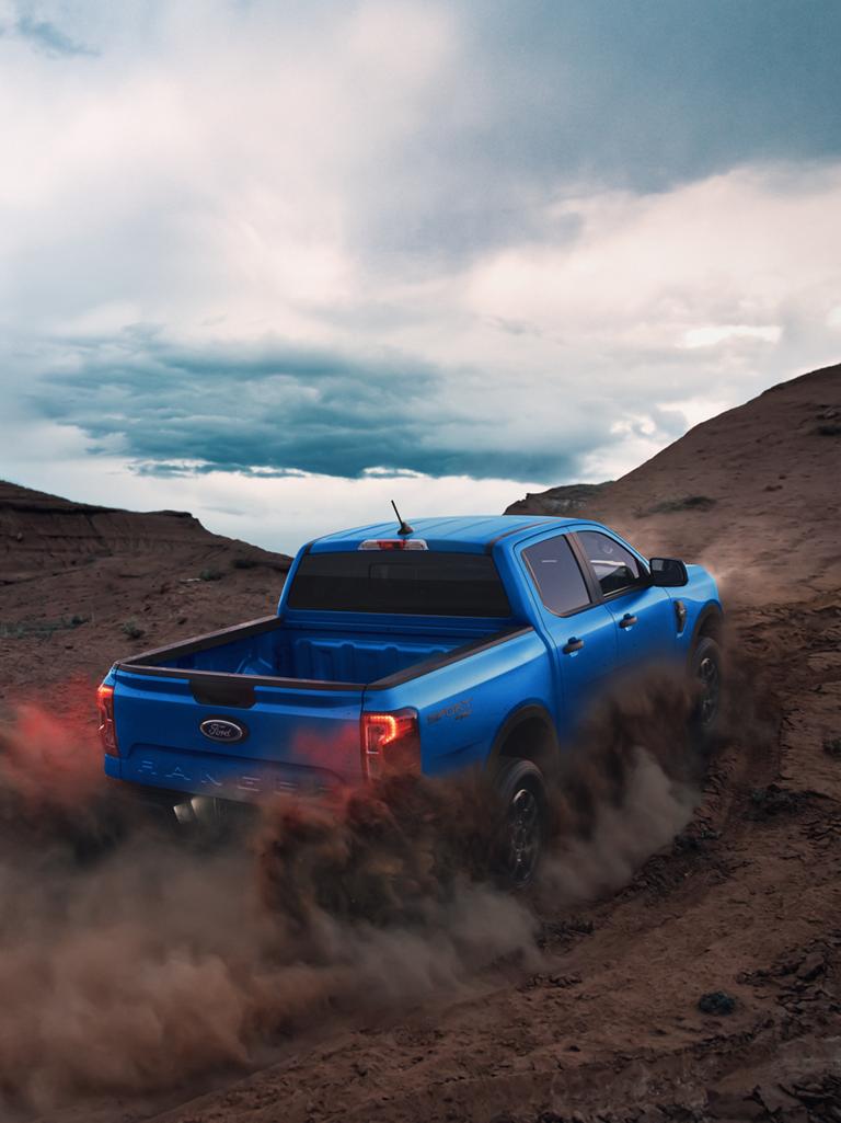 2026 Ford Ranger® XLT kicking up dirt as it drives up a hill