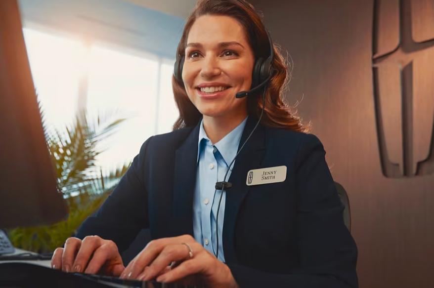 Une femme tape sur un clavier tout en parlant dans un casque.