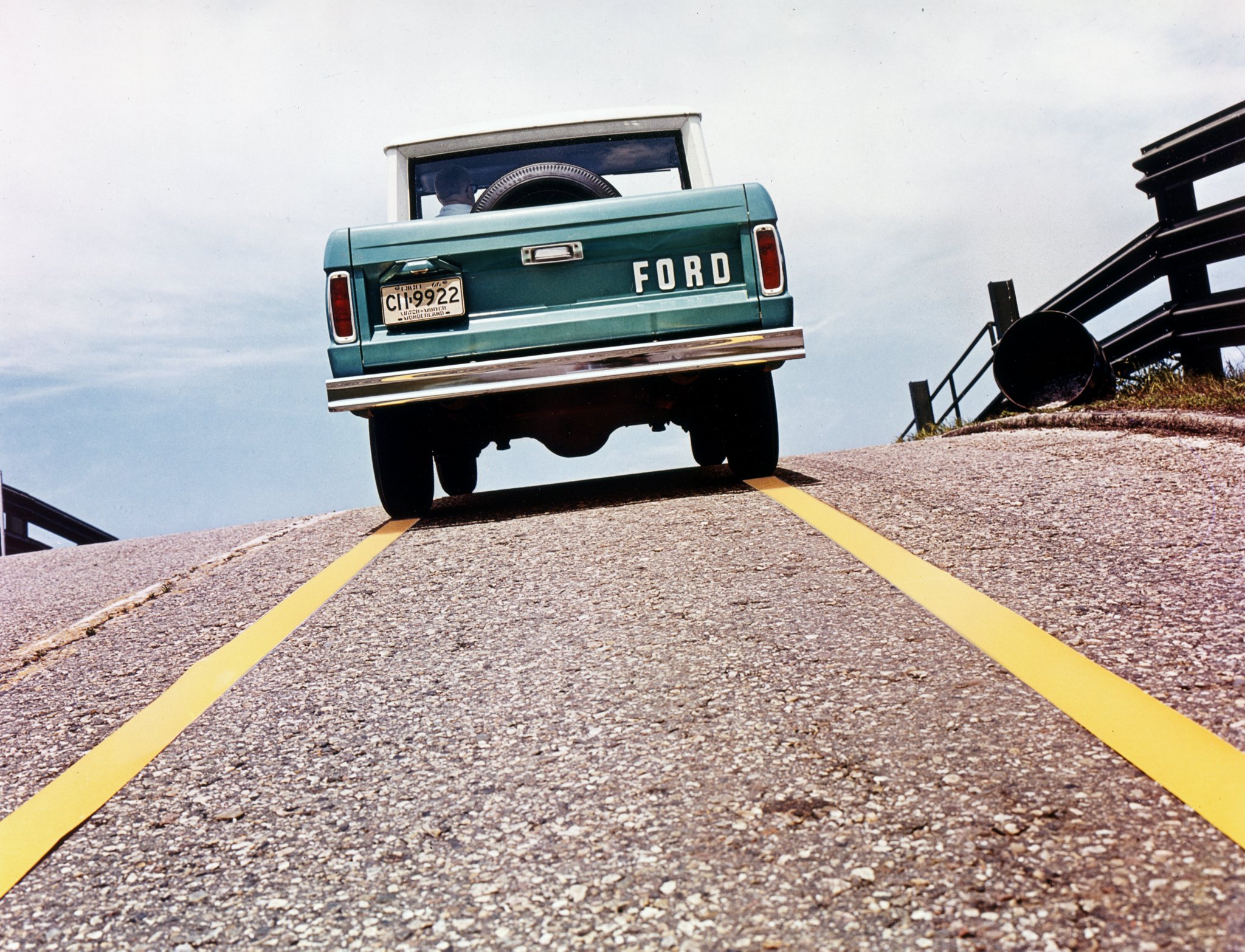 Vue arrière d’un Ford Bronco 1967 circulant sur une colline