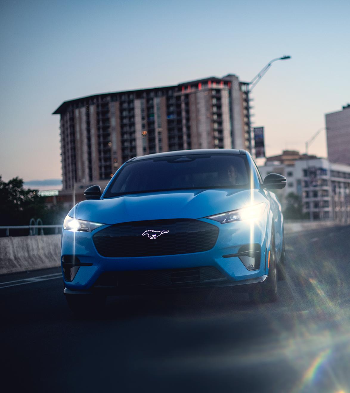 Modelo Mustang Mach-E® GT 2026 andando por una calle urbana