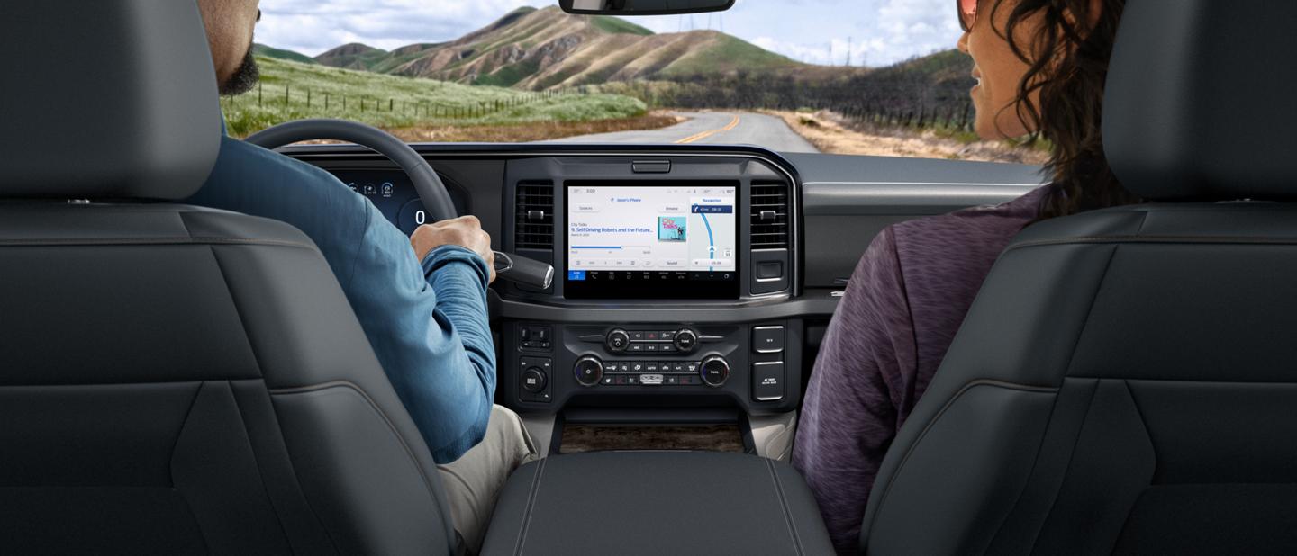 Man and woman sitting in a 2025 Ford Super Duty® F-450® Limited pickup showing the center display navigation screen