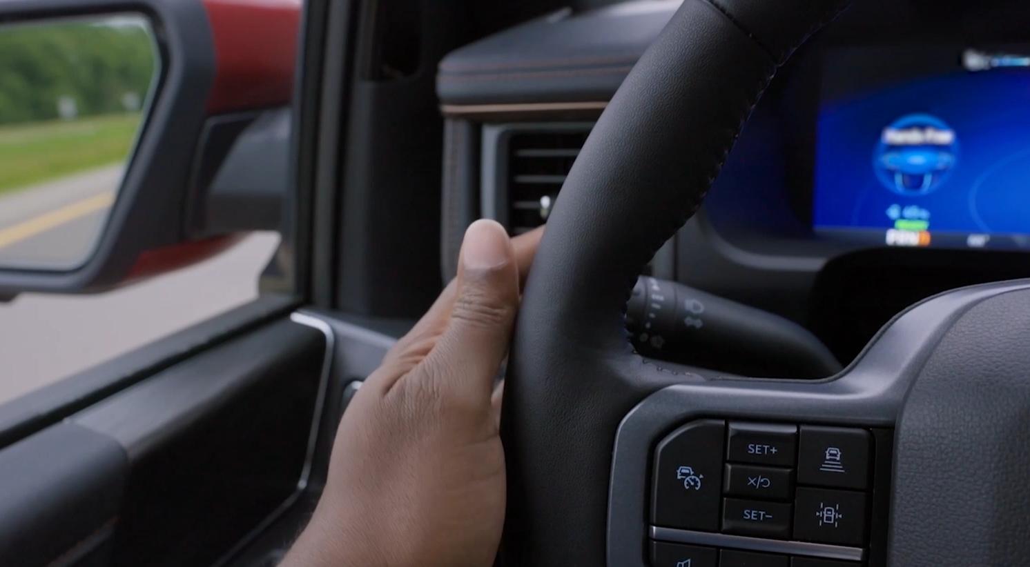 A driver with hands on the wheel of a 2025 Ford F-150® Lightning® truck