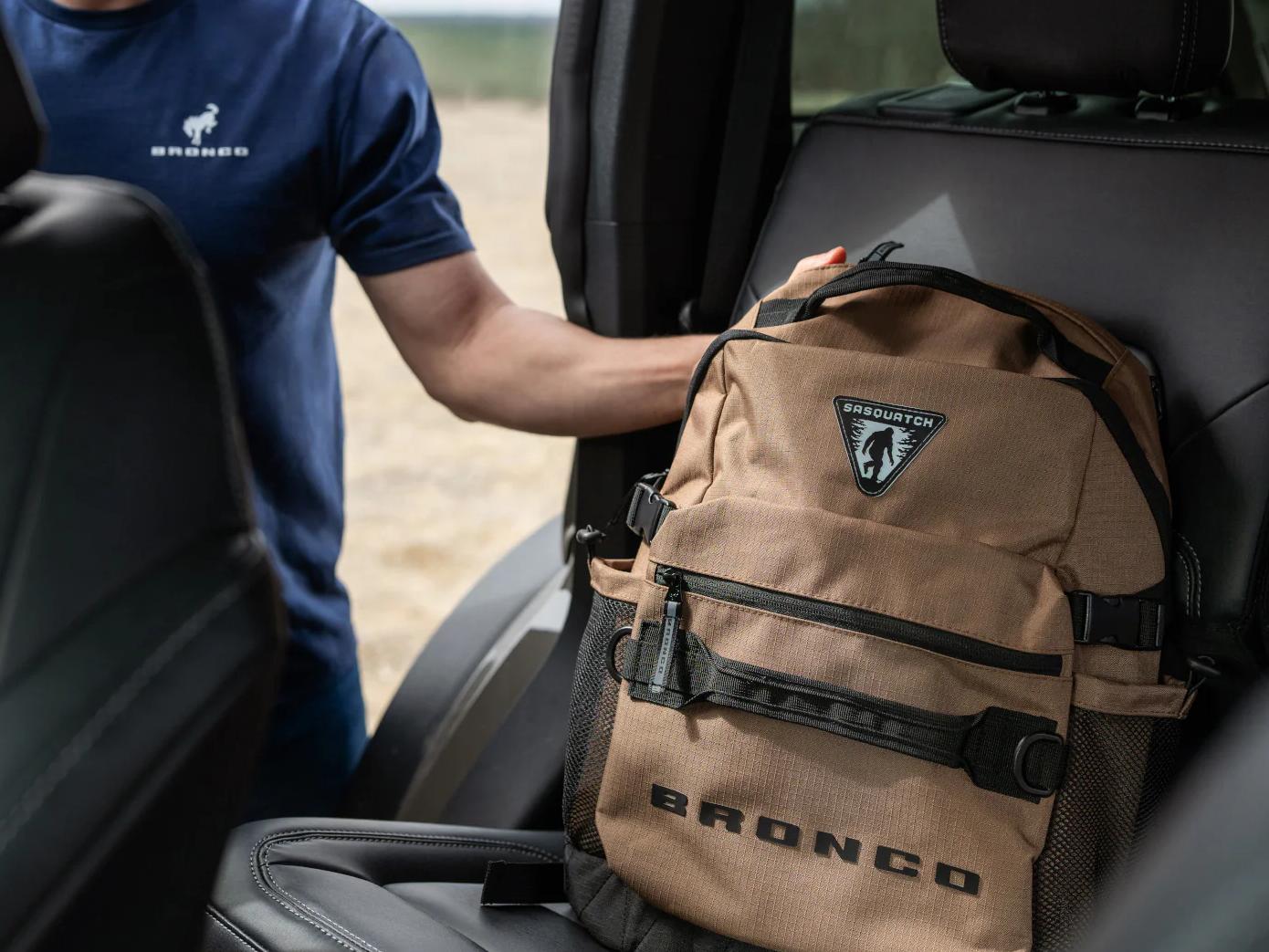 Person putting a Bronco®-branded backpack on the seat of a Ford Bronco® SUV
