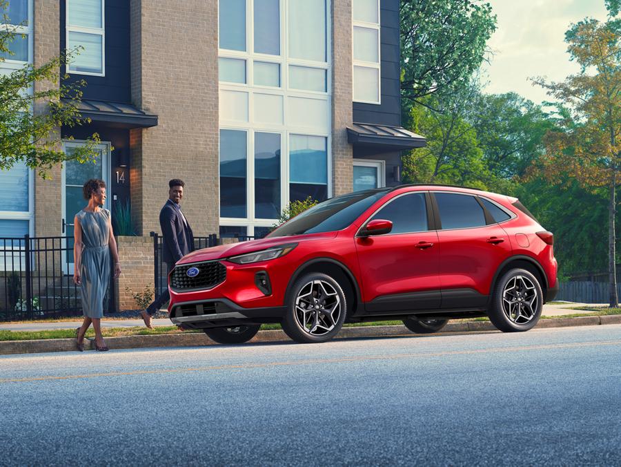 Couple walking up to a Rapid Red 2026 Escape® SUV