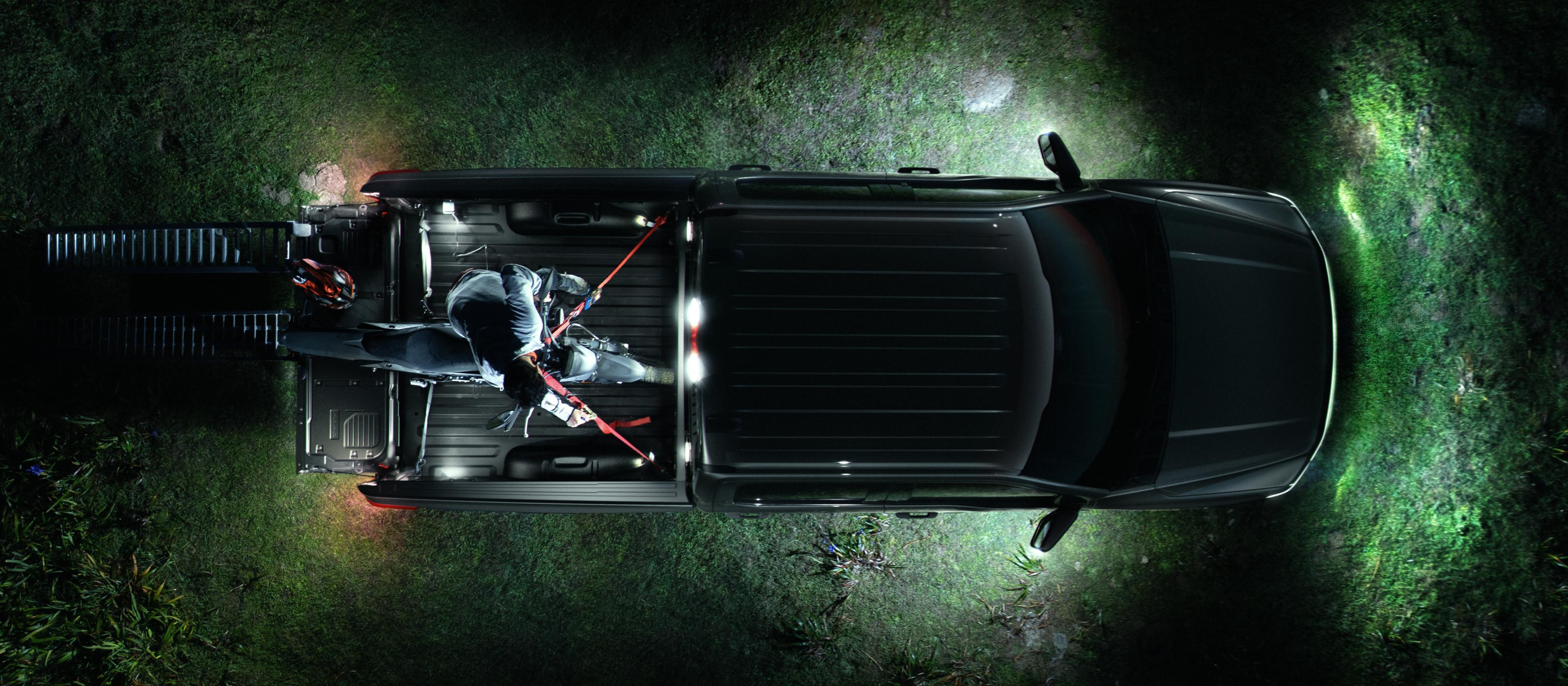 An overhead view of a 2025 Ford F-150® Lightning® pickup, with the LED Zone Lighting illuminating the area around