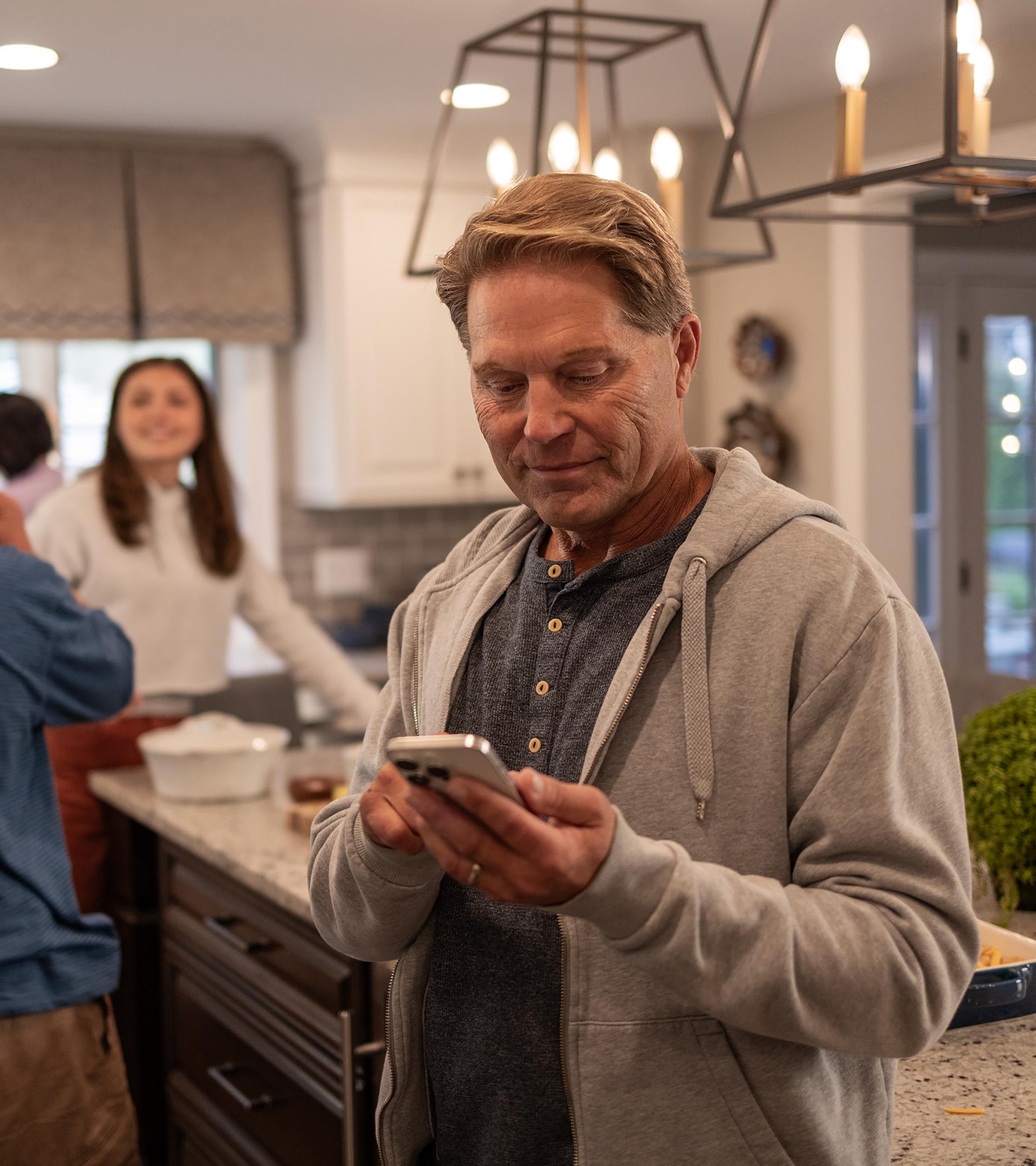 An owner receives a welcome text from their Ford Advisor while their family snacks in the kitchen