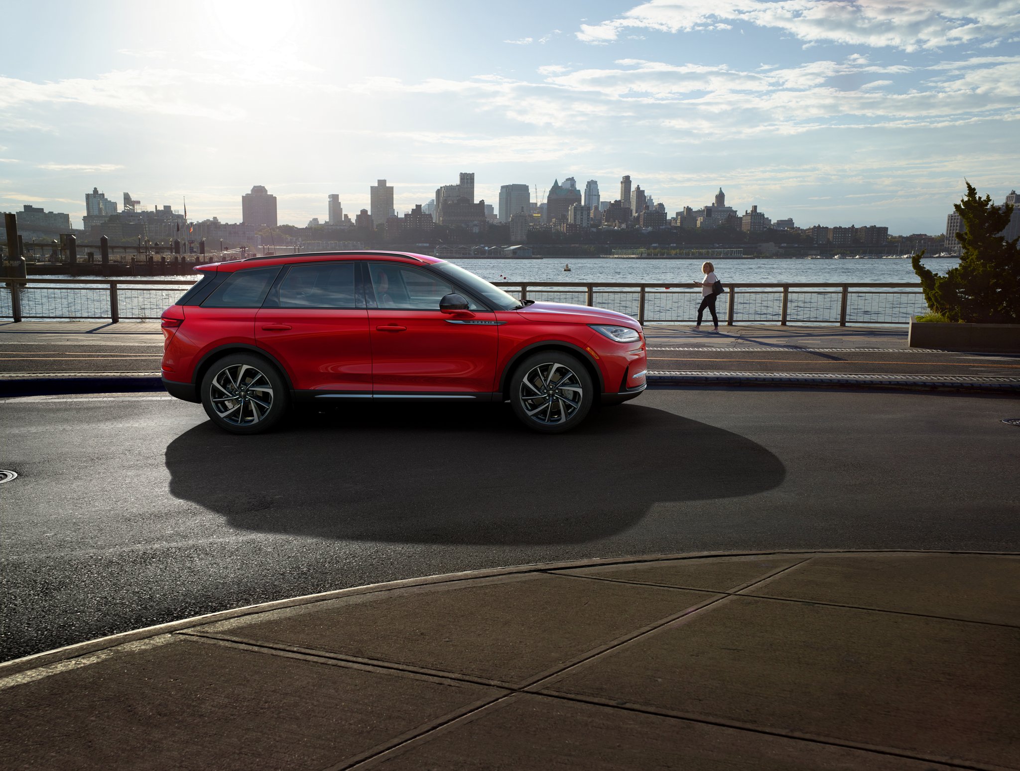 A 2026 Lincoln Corsair in the Red Carpet exterior colour is parked next to a waterside park